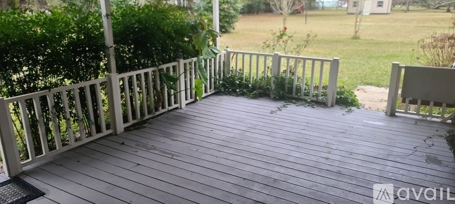 A wooden deck with a railing and a chair.