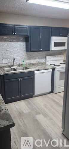 A kitchen with black cabinets and a white oven.