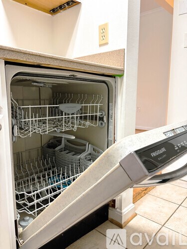A dishwasher with the door open and a digital display on the control panel.