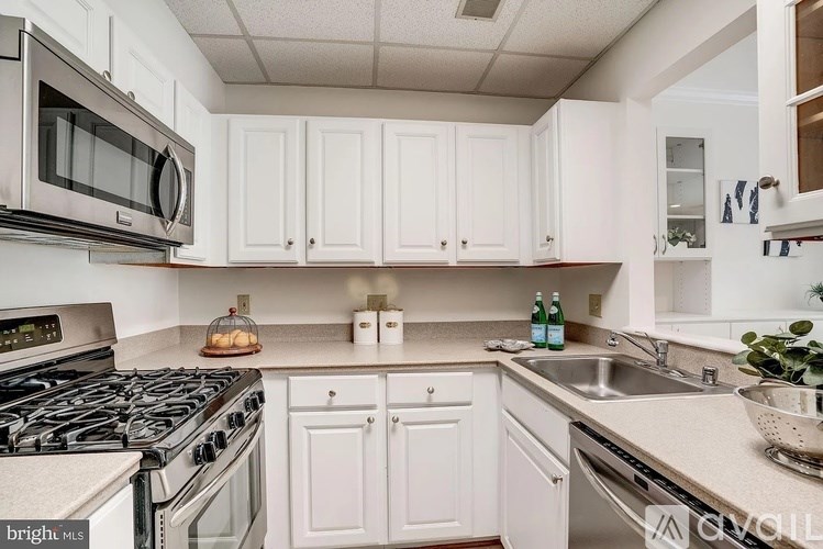 A kitchen with white cabinets and a black stove top.