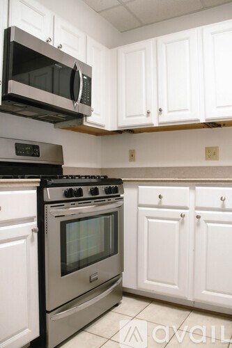 A white bathroom with a sink, mirror, and toilet.