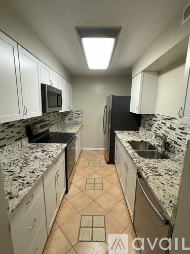 A kitchen with granite countertops and tile flooring.