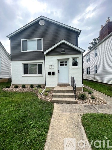 A two-story house with a front yard and a white door.