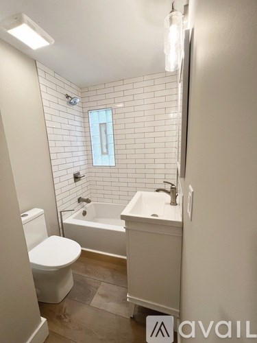 A white bathroom with a toilet, sink, and tub.