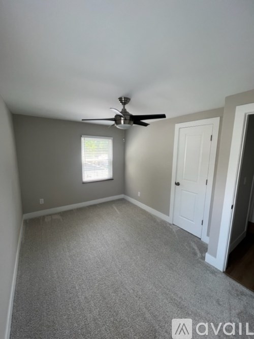 A room with a ceiling fan and a window.