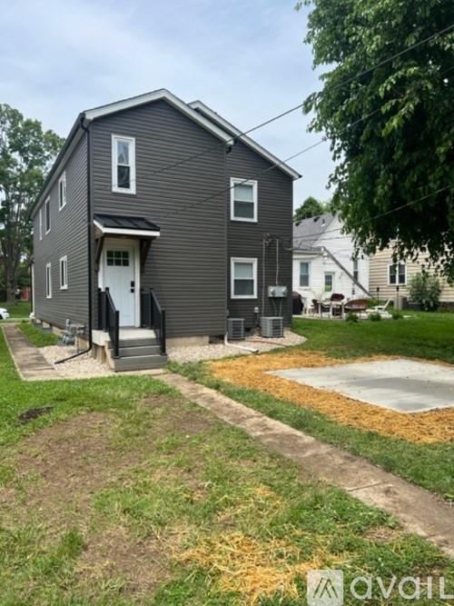 A grey house with a white door and windows.