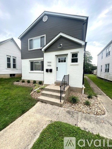 A small house with a front yard and a number 166 on the front door.