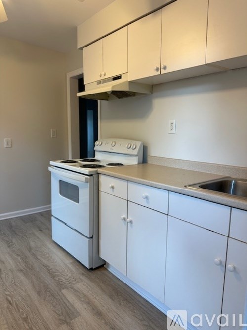 A kitchen with white appliances and cabinets.