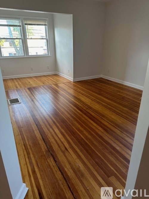 A room with wooden flooring and a window.