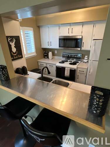 A kitchen with white cabinets and a stove top oven.