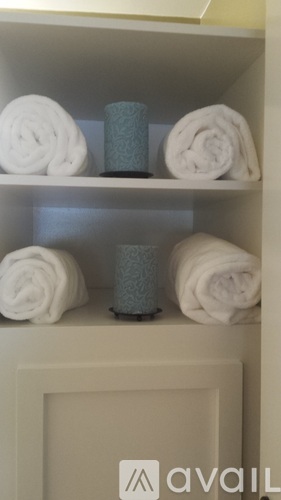 A shelf with towels and candles on it.