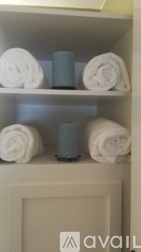 A shelf with towels and candles on it.