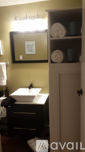 A bathroom with a sink, mirror, and towel rack.