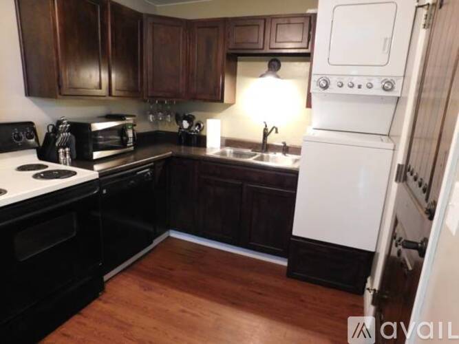 A kitchen with a black stove top oven and a white refrigerator.