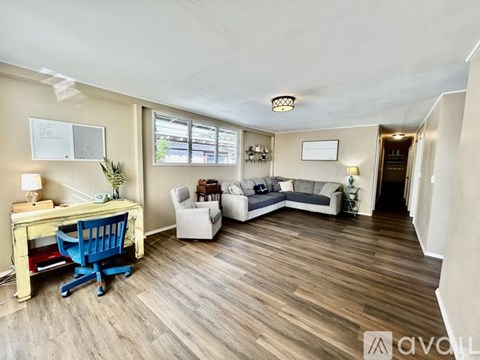 A living room with a blue chair and a white couch.