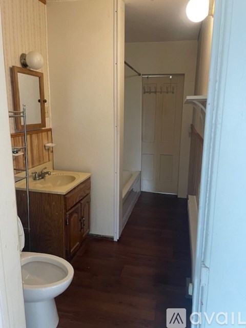 A bathroom with a toilet, sink, and a mirror.