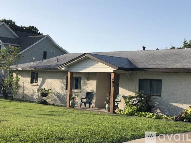 A house with a covered porch and a lawn in front.