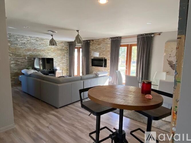 A living room with a stone wall and a grey couch.