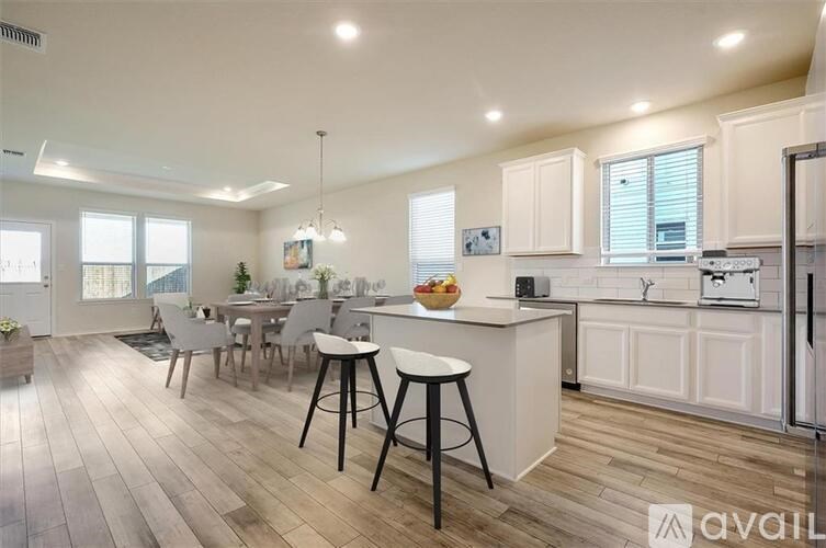A kitchen with white cabinets and a wooden floor.