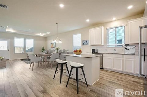 A kitchen with white cabinets and a wooden floor.