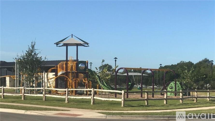 A playground with a yellow slide and a gazebo.