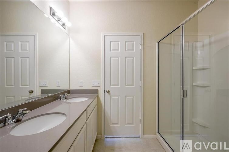 A bathroom with a mirror, two sinks and a shower.