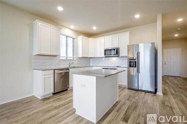 A kitchen with white cabinets and a wooden floor.