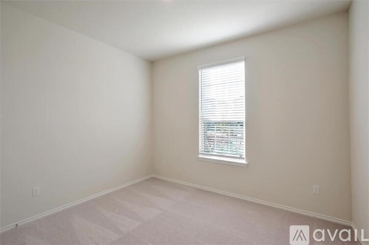 A room with a window and a carpeted floor.
