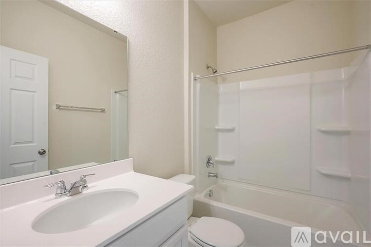 A white bathroom with a toilet, sink, and bathtub.