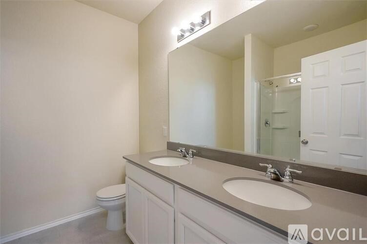 A bathroom with a white toilet and a double sink vanity.