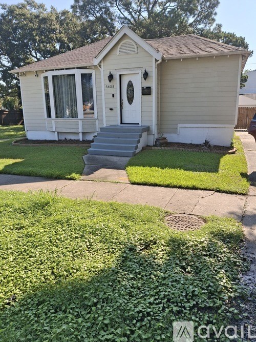 A small house with a front yard and a mailbox on the right.