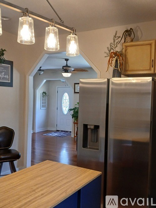 A kitchen with a wooden counter and a fridge.