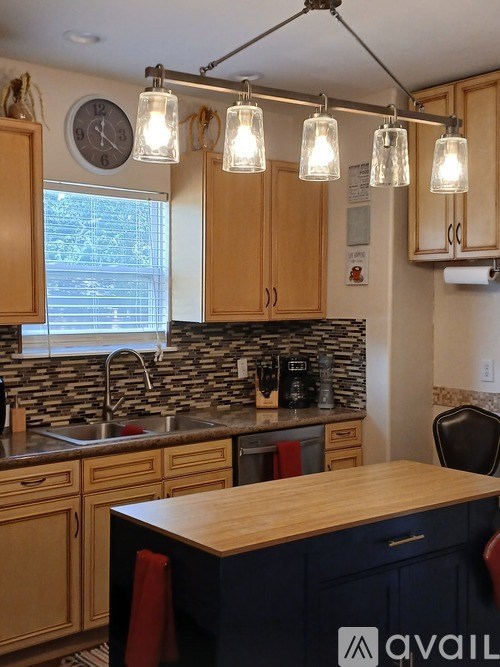 A kitchen with wooden cabinets and a stone backsplash.