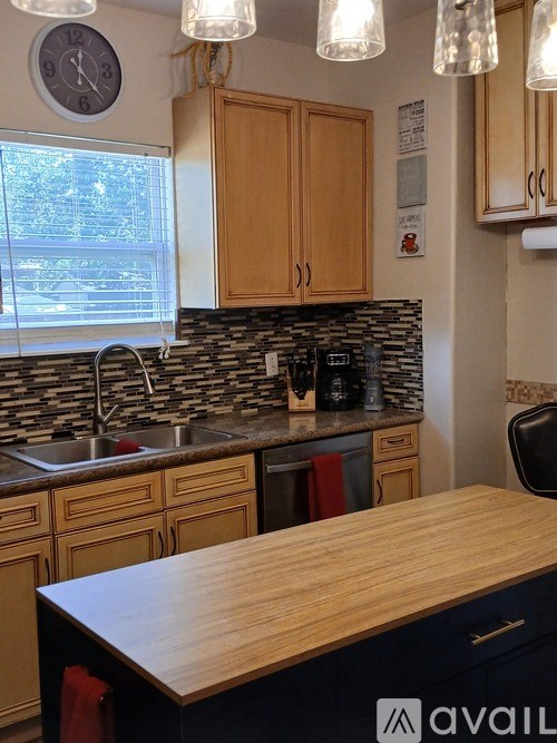 A kitchen with wooden cabinets and a stone backsplash.