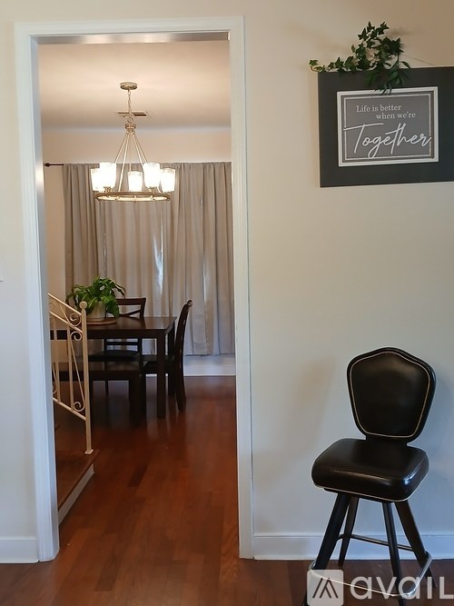 A black chair is in front of a wall with a sign that says "Life is better when we are together.".