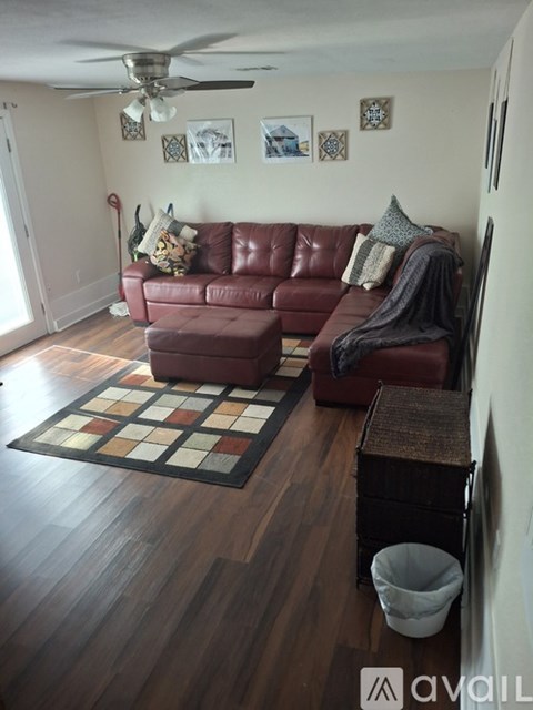A living room with a red couch and a rug.