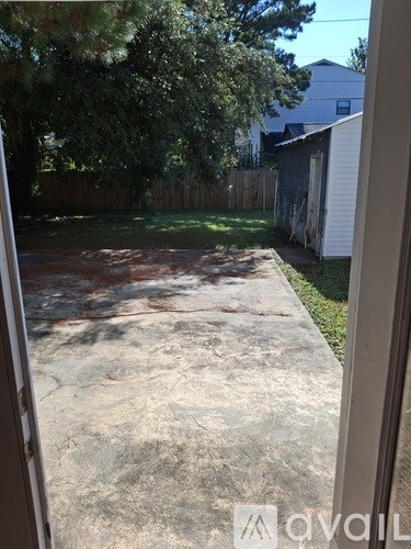 A backyard with a concrete slab and a fence.