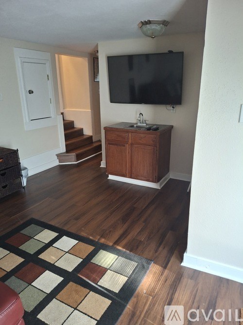 A living room with a television and a wooden cabinet.