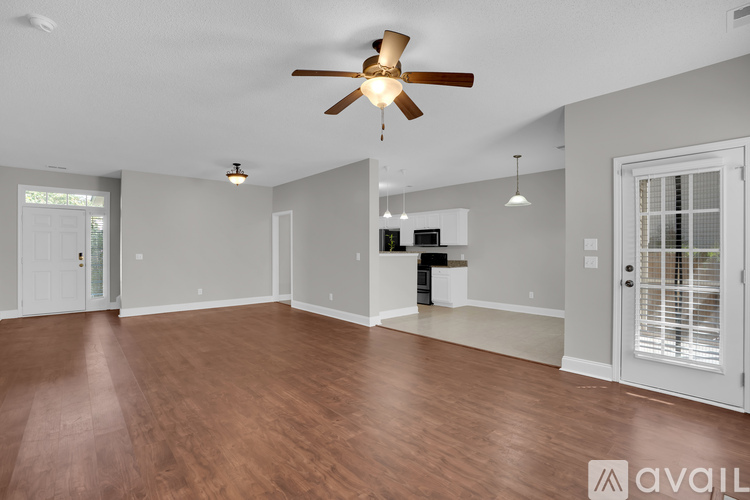 A spacious room with a ceiling fan and wooden flooring.