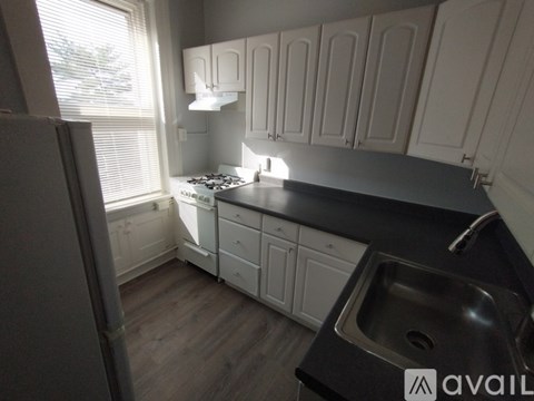 A kitchen with wooden cabinets and a black countertop.