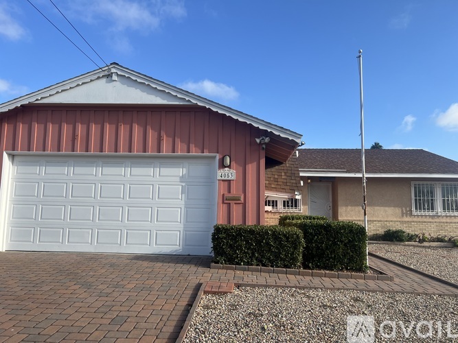 A house with a red roof and a white garage door.