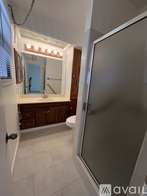 A bathroom with a mirror and lights above it.