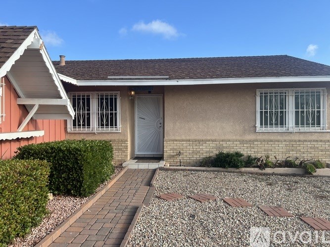 A house with a grey door and windows with white frames.