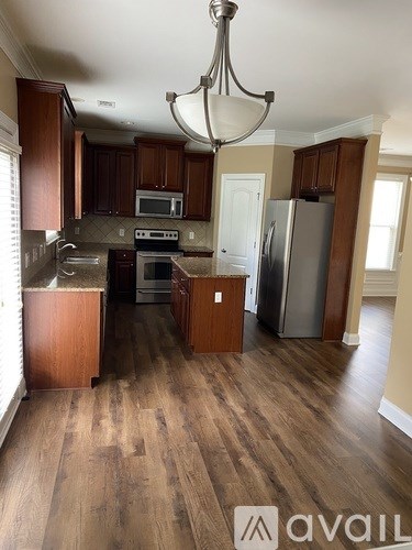 A kitchen with wooden cabinets and a chandelier.
