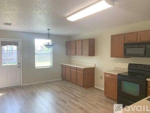 A kitchen with wooden cabinets and a black oven.