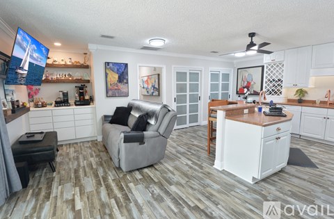 A living room with a grey couch and a television on the wall.