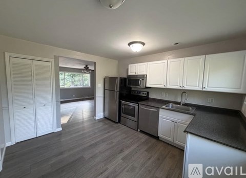A kitchen with white cabinets and a black countertop.