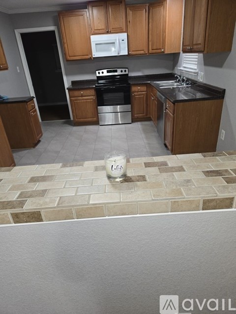 A kitchen with wooden cabinets and a tile floor.