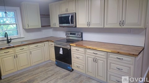 A kitchen with wooden cabinets and a black oven.