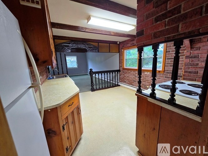 A kitchen with a white refrigerator and wooden cabinets.